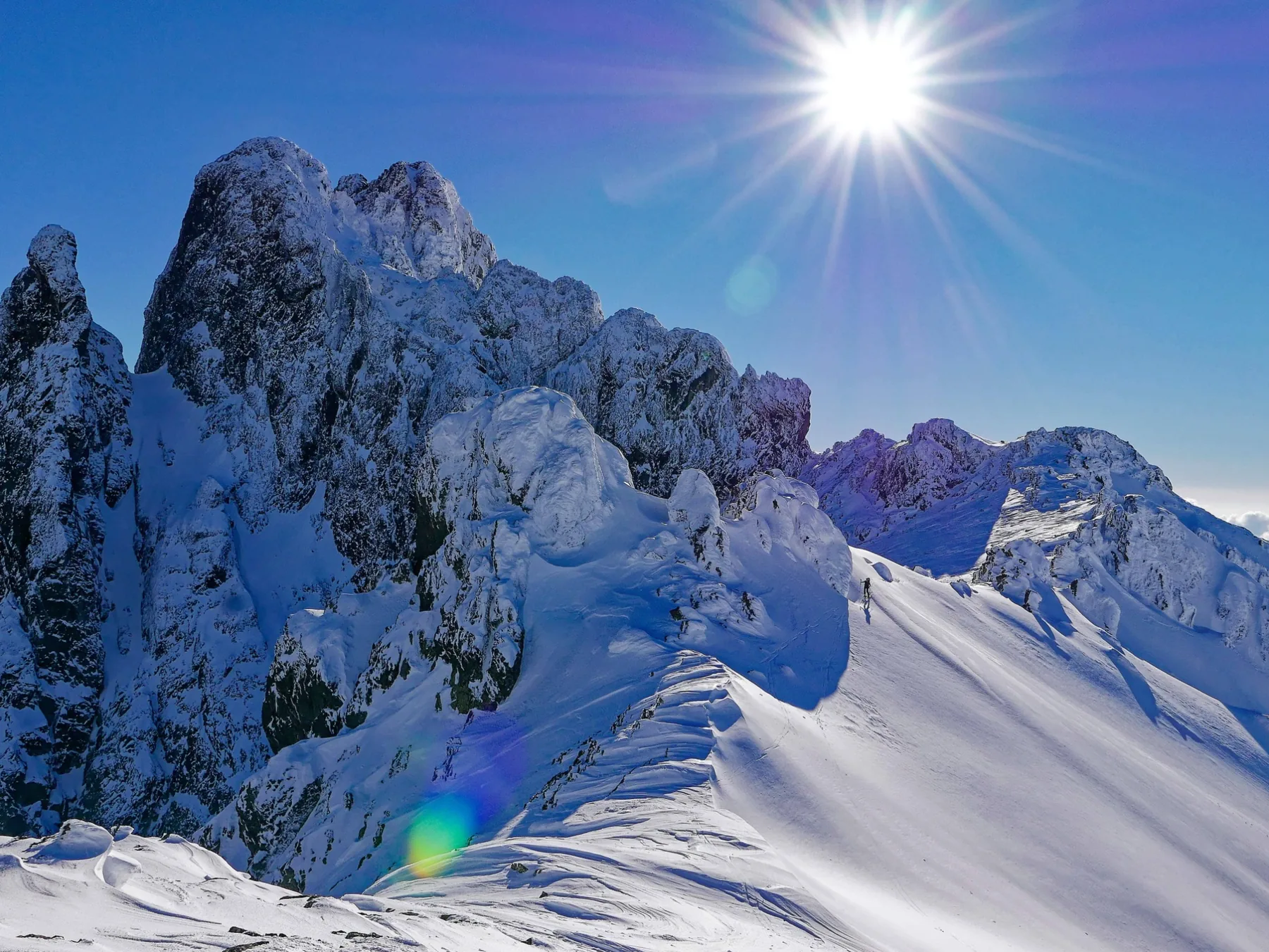 Arêtes rocheuses et reliefs enneigés pendant l’ascension du Monte Cinto à ski de randonnée, en Corse.